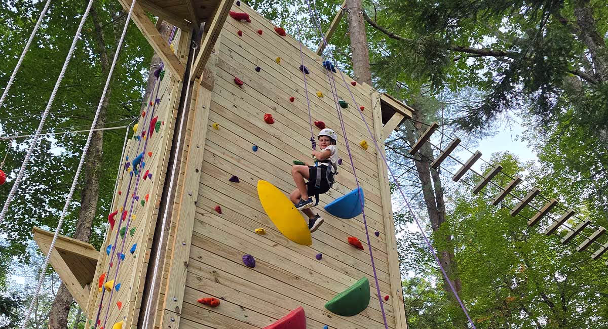 A day camper climbing Adventurelore’s outdoor wall
