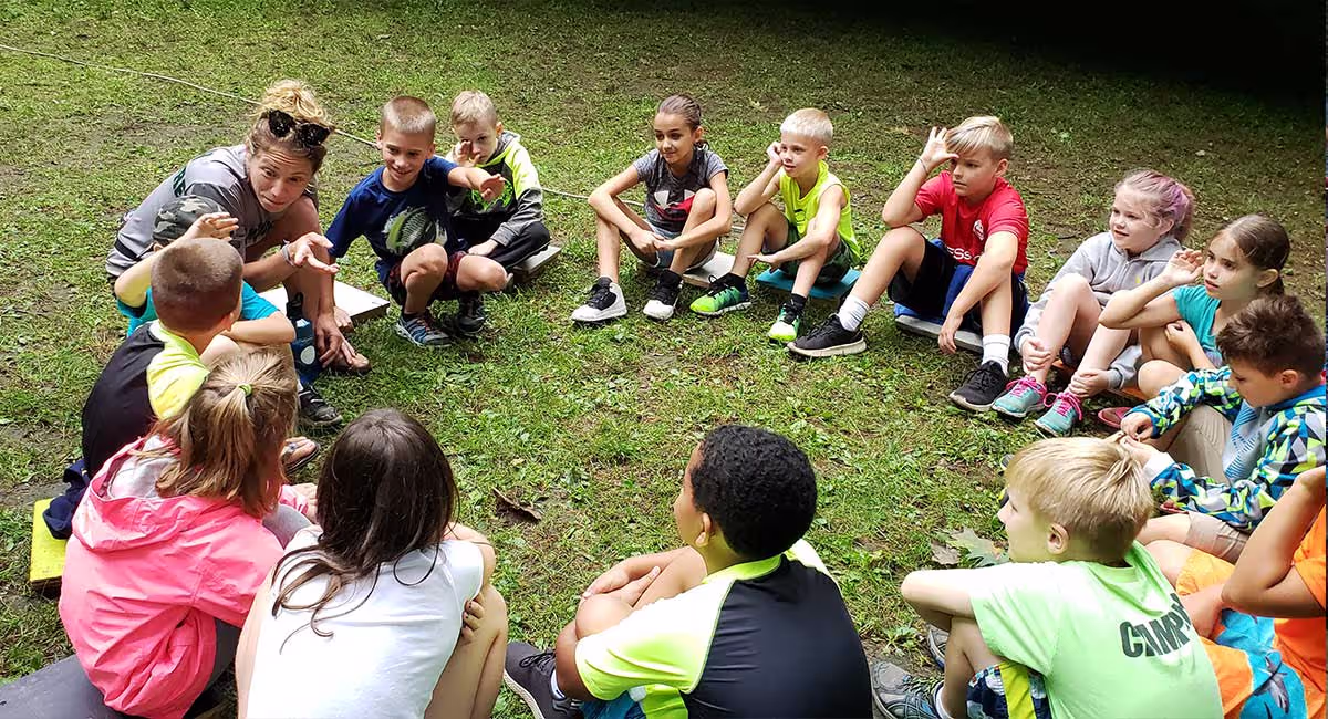 Day campers sitting together in a group outdoors