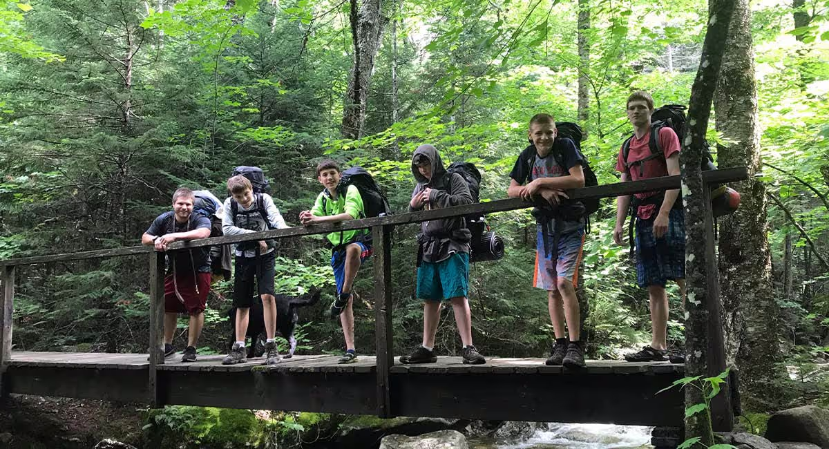 White Mountains campers on a forest footbridge