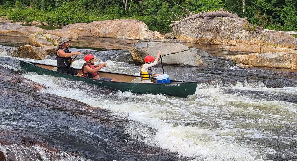 White Mountains campers paddling down a river