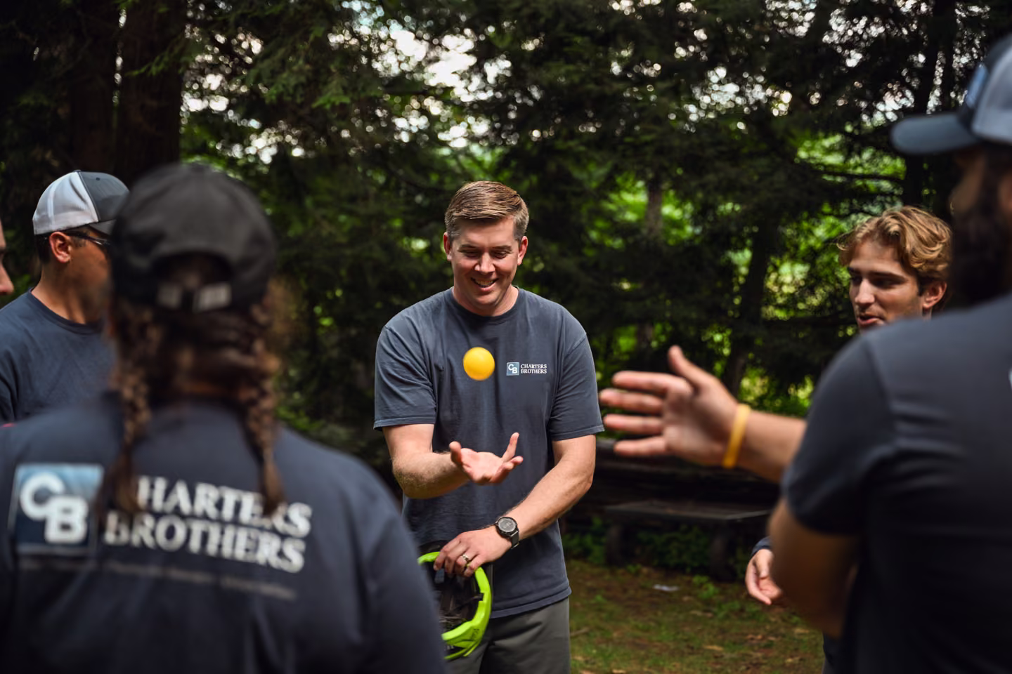 Adult teammates smiling as they take part in an outdoor ball activity